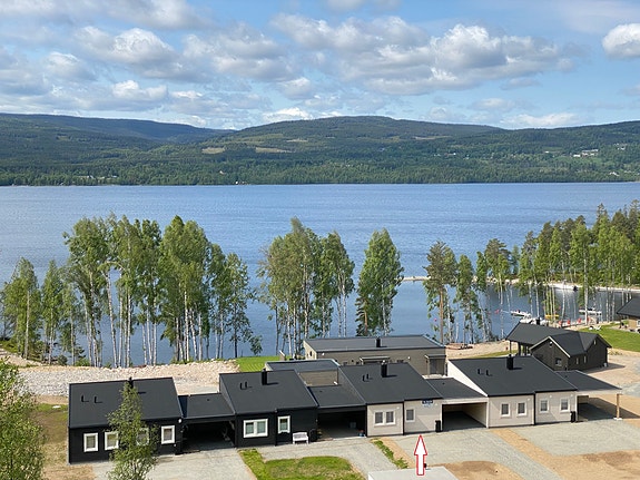 Leiligheten merket med pil har flotte uteplasser både på skygge. og solsiden, i tillegg til romslige parkeringsarealer, carport og utvendig stor sportsbod.