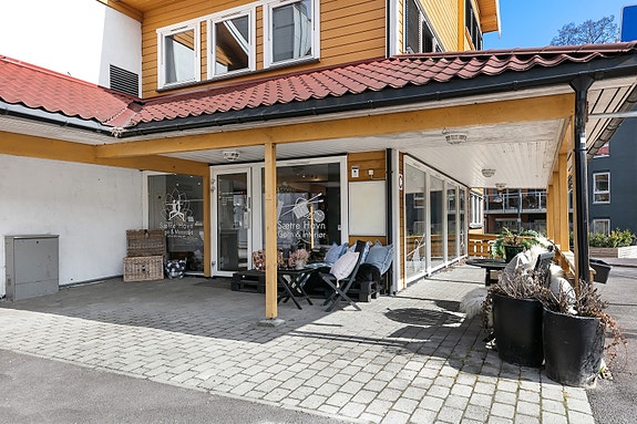 Overbygd inngangsparti med hellelagt uteareal.