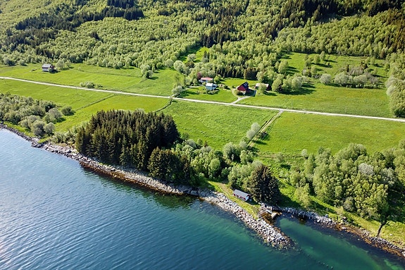 Innholdsrik gård med 2 bolighus, fjøs, garasje og stort redskapshus/lager/garasje samt naust med havneanlegg.
