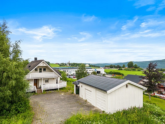 Steinlagt gårdsplass og stor dobbelgarasje.