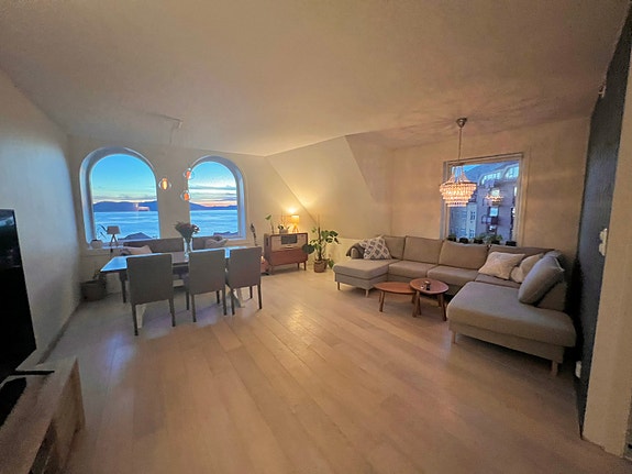 Stuen er moderne, lys og åpen, med stor hjørnesofa, tv og spisestue