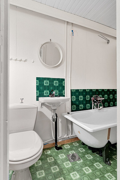 Det er ett baderom i kjeller fra 1997, dette betegnes ikke som våtrom. Rommet er innredet med eldre toalett, badekar og en servant.