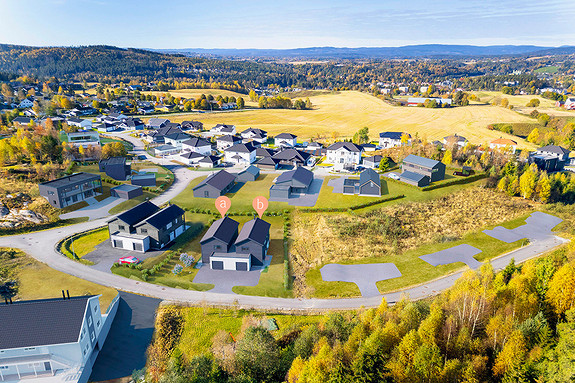 Boligenes beliggenhet sett fra øst, Eidsvoll sentrum bak til høyre i bildet. Illustrasjon av boligene merket med a og b.