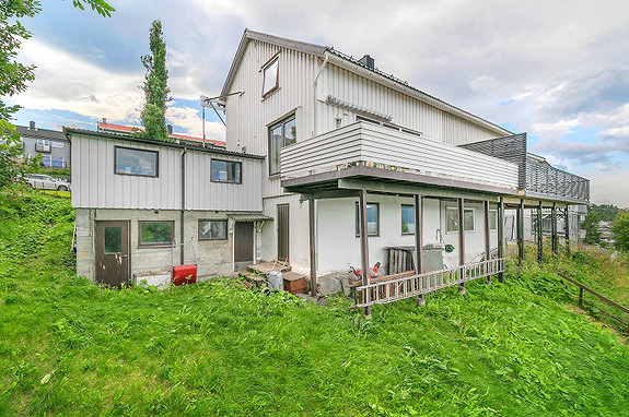 Det er også inngangsdør til kjeller fra nedsiden av boligen. Under garasjen er det bod med lagringsplass