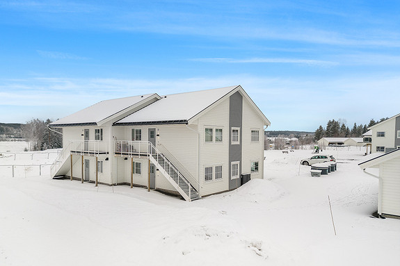 Foto av leilighetsbygg inngangsparti. Aktuell leilighet 3D øverst til venstre.