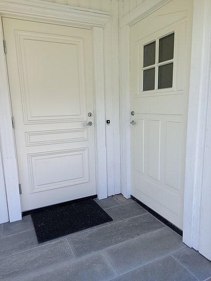 Inngangsdør og liten utvendig bod