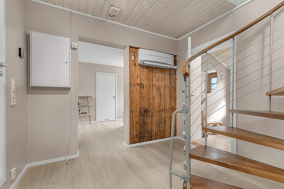 Romslig hall med tilhørende kjellerstue. Legg merke til den gamle treveggen, samt den spennende trappen som er montert i boligen!