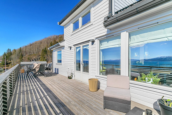 Verandaen strekker seg rundt hjørnet på den ene siden, noe som gir god plass for å invitere til større sammenkomster.