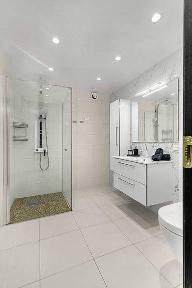 Badet er velutstyrt med servantskap, vegghengt skap, downlights i himling, dusjhjørne med rainshower og varme i gulv.