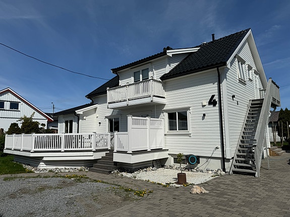 Trapp opp på siden av huset er til leiligheten. På bilde ser man også verandaen tilhørende 2etg.