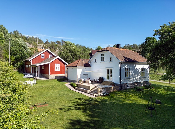 Den hvitmalte eneboligen fra tidlig 1900-tall ligger vakkert plassert i det åpne kulturlandskapet og minner om et tradisjonelt gårdsbruk med en stor rødmalt låve som faktisk er en garasje.