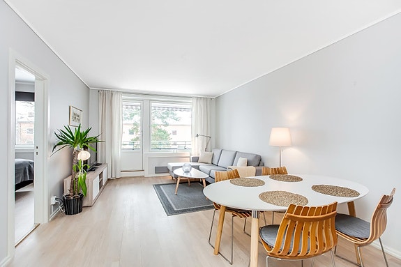 Stue med sofa og spisegruppe. Utgang til vestvendt balkong.
