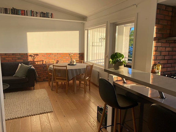 Fra gangen ser vi bardisken på kjøkkenet, spisestuen og litt av sofaen.