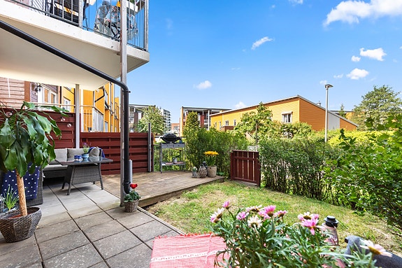 Fra stuen er det utgang til en herlig uteplass med både terrasse og en liten gressplen.