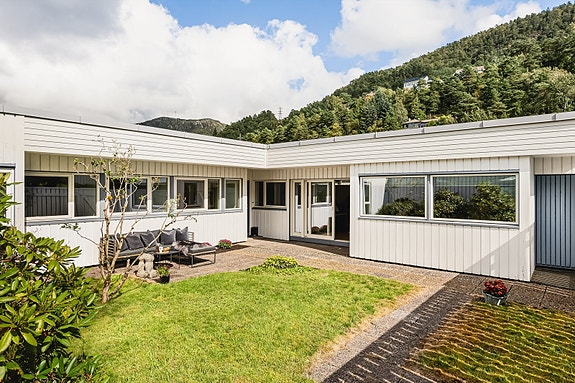 Boligen ligger omslynget en skjermet hage med gode solforhold.