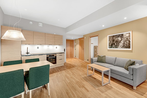 Hotelleilighet - Spiseplass og kjøkken i åpen løsning med moderne innredning og godt med skapplass.