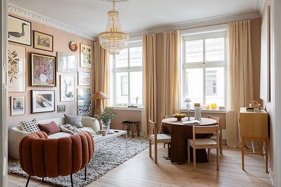 Lys og innbydende stue med store vinduer og elegant stukkatur