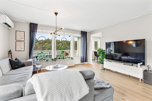 Stuen er et lyst og hyggelig rom med god plass til sofagruppe og øvrig ønsket møblement. Rommet har et fint lysinnslipp fra store vinduer og terrassedør.