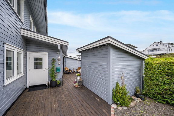 Pent opparbeidet inngangsparti med mye uteplass og en praktisk utebod