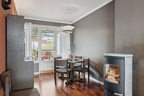 Kombinasjonen av moderne stil og vedovn gir stuen et lunt og innbydende preg.