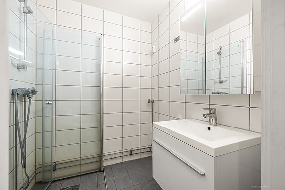 Moderne baderomsinnredning med opplegg for vaskemaskin.