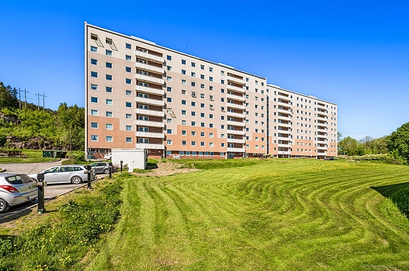 Fasade med inngangsparti, nært til barnehage, barneskole og idrettsanlegg.