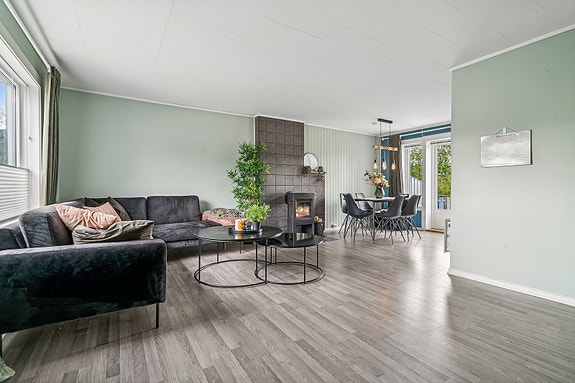 Lys og trivelig stue med stilrene overflater. Stuen er møbleringsvennlig og fremstår som innbydende, med soner for både sofagruppe, og spisestue.