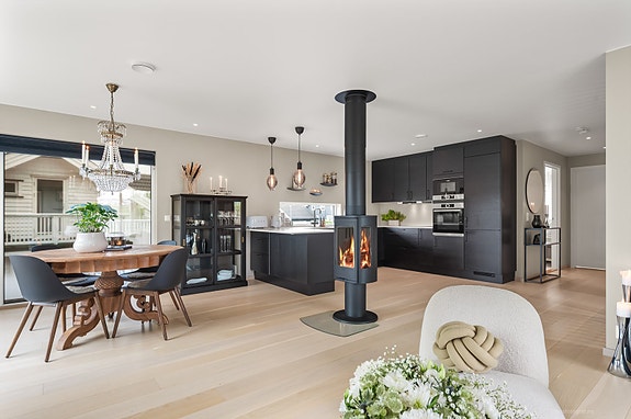 Sentralt i stuen står en lekker peisovn som synes fra flere vinkler.