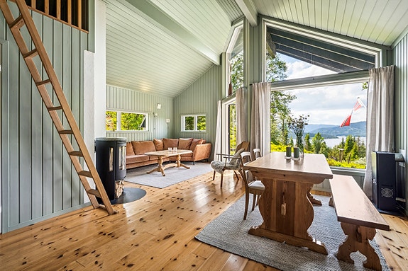 Hytta har en romslig stue med god takhøyde som gir en luftig atmosfære.