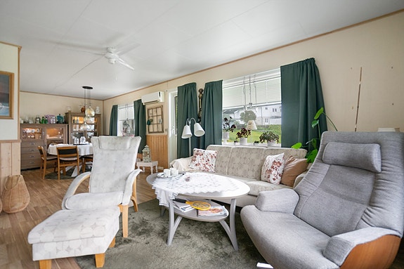 Åpen og innbydende stue med store vindusflater som slipper inn rikelig med dagslys