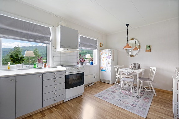 Kjøkken med store vinduer som slipper inn rikelig med dagslys og gir fin utsikt