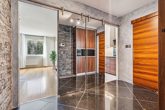Stor entrè med integrert garderobe og skyvedører med speilfronter