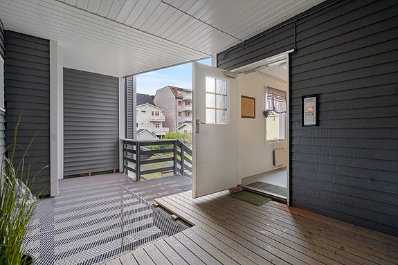 Inngangspartiet er overbygd og skjermet for vær og vind - gir et godt førsteinntrykk før du trer inn i den lyse leiligheten