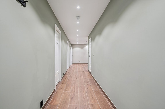 Velkommen inn - en lys og innbydende entré med spotlights i taket som gir et elegant førsteinntrykk.