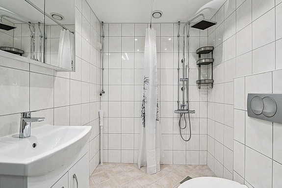 Et moderne baderom med god plass, flislagte overflater og tidløs design.