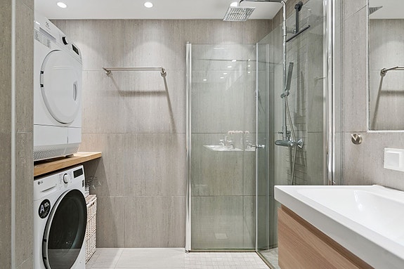 Stilrent bad fra 2016 med dusjhjørne og opplegg for vaskemaskin/tørketrommel.