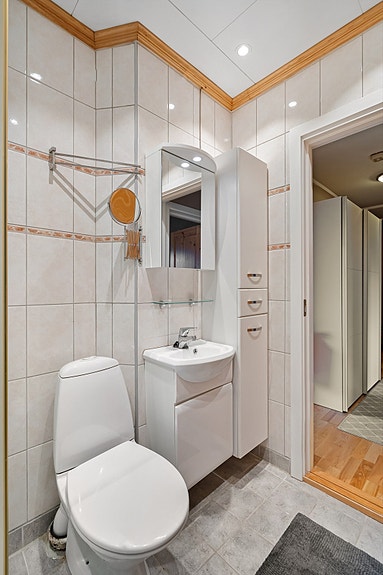 Badet har praktiske oppbevaringsløsninger med både underskap, speilskap og veggehengt skap