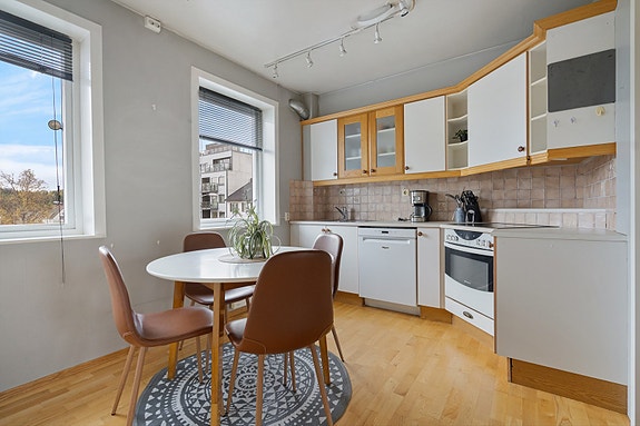 Kjøkkenet er innredet med lyse fronter og fliser over benk. Her er det plass til alt du trenger for matlaging