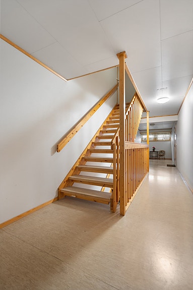 Lys og romslig trappeoppgang med god takhøyde og brede trapper