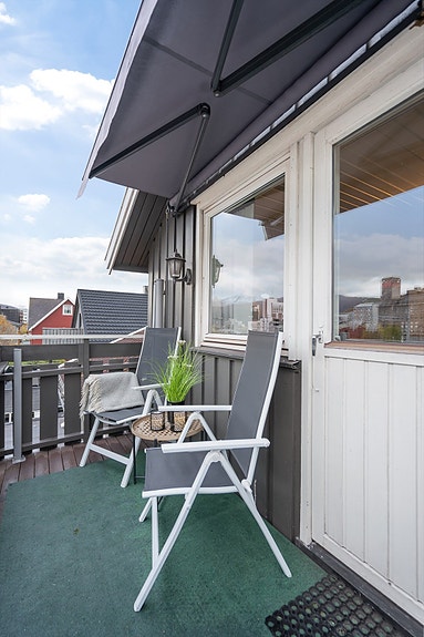 Lun og trivelig balkong med plass til sittegruppe. Her kan du nyte frisk luft og utsyn over nærområdet - med markise for skygge på varme dager
