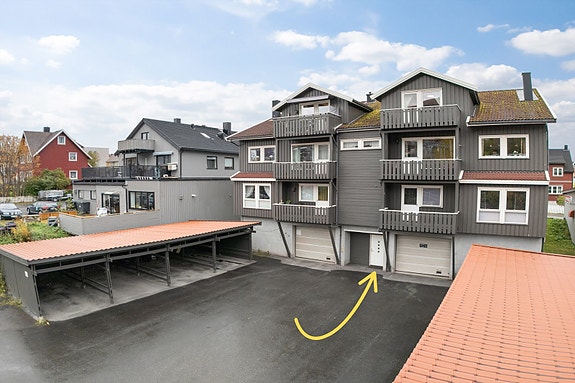 Praktisk inngang fra baksiden av bygget, med nærhet til parkeringsplass og bod - ideelt for hverdagen