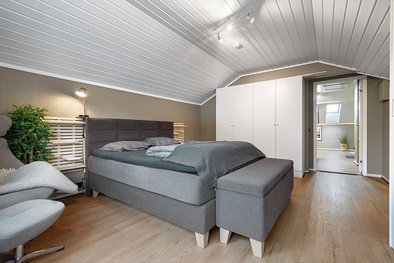 Romslig soverom med god plass til dobbeltseng, garderobeskap og sitteplass. En rolig og behagelig sone å trekke seg tilbake til