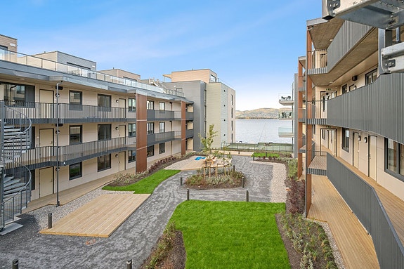 Godt vedlikeholdte fellesarealer med benker, grønt og beplantning.