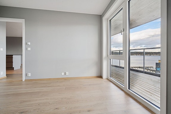 Luftig soverom hvor du kan nyte utsikten over fjorden fra sengen.