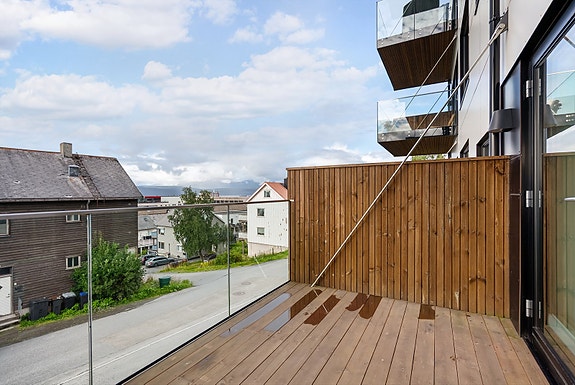 Romslig balkong med glassrekkverk som gir et moderne preg og slipper inn mye lys