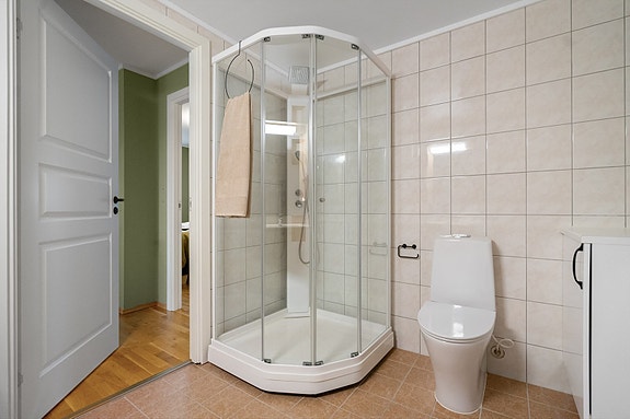 Badet er utstyrt med dusjkabinett, toalett og servant - alt du trenger i et praktisk og velholdt baderom
