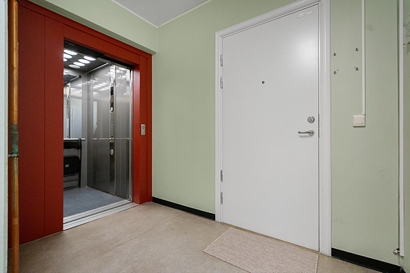 Lys og velholdt fellesgang med postkasser og oppgang til de øvrige etasjene