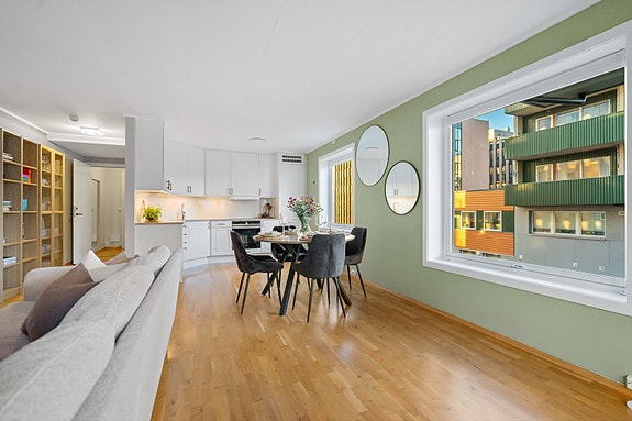 Rommet oppleves moderne og innbydende, med grønne vegger som tilfører karakter og ro