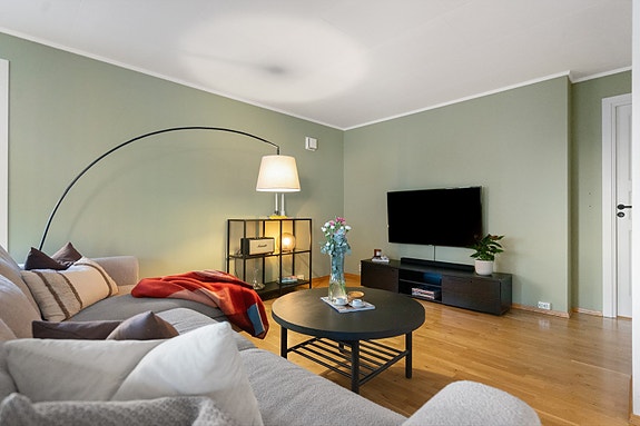 Behagelige fargetoner og store vinduer bidrar til en lun og harmonisk stemning, perfekt for både hverdag og hyggelige kvelder