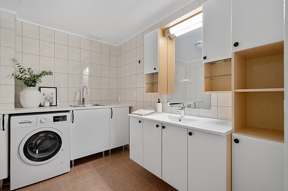 Baderommet har både vaskesone og plass til vaskemaskin - en funksjonell løsning for hverdagen